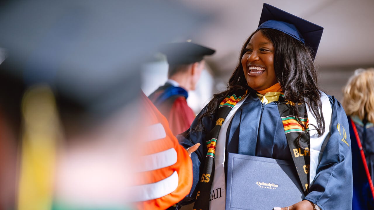 Student shakes individuals hand