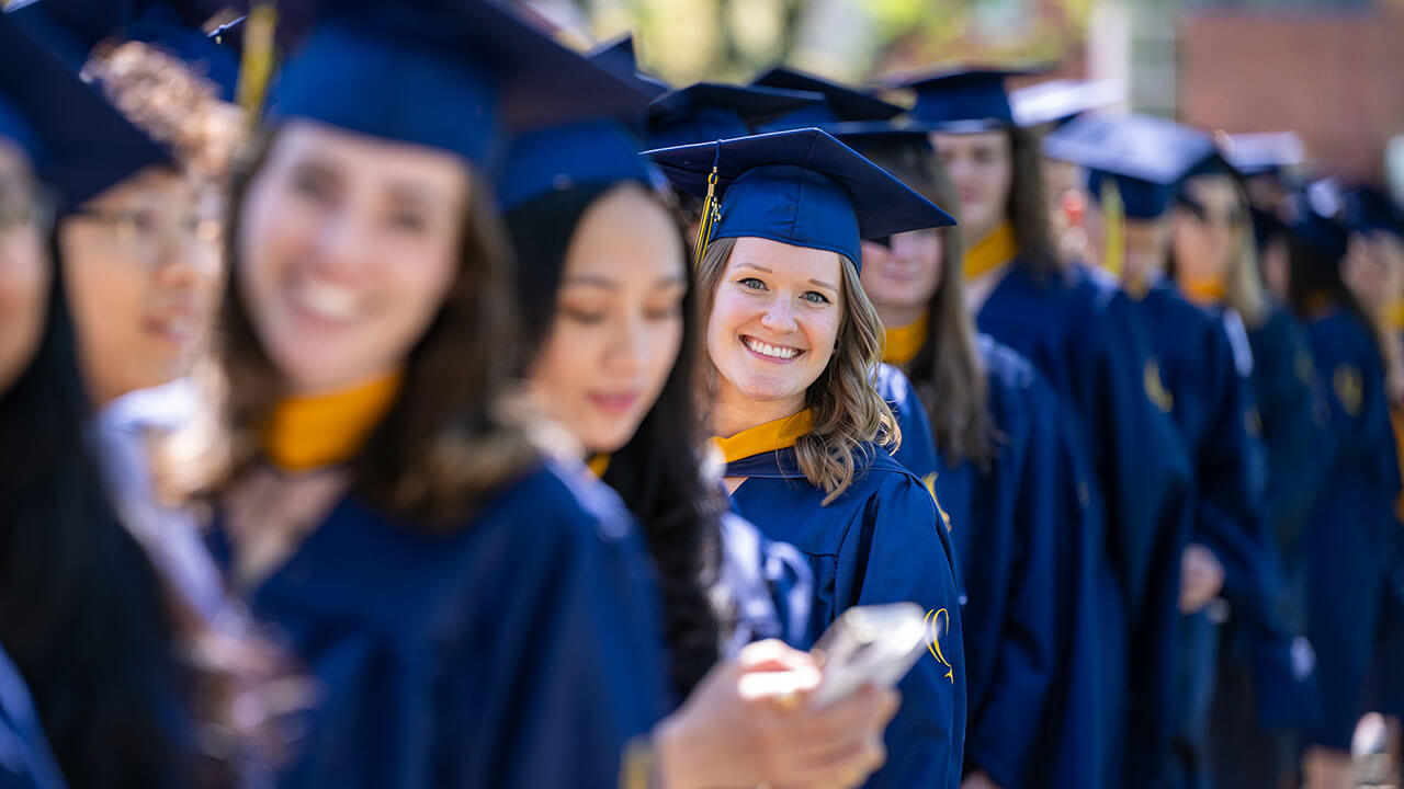 A student leaning out of line and smiling