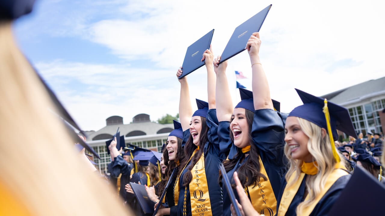 Students holding degrees in the air