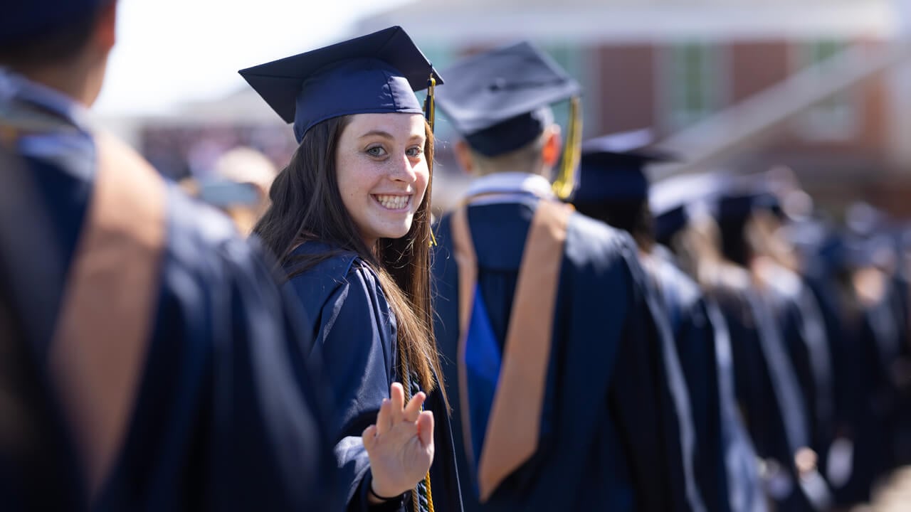 Student waves to camera