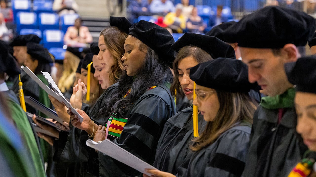 row of graduates reads out the netter doctor's oath from their programs