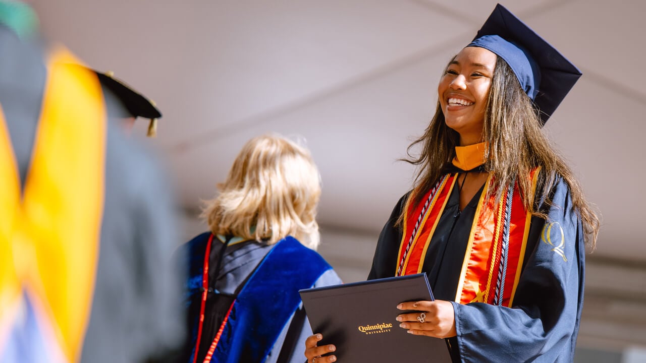 Student smiles walking across the stage