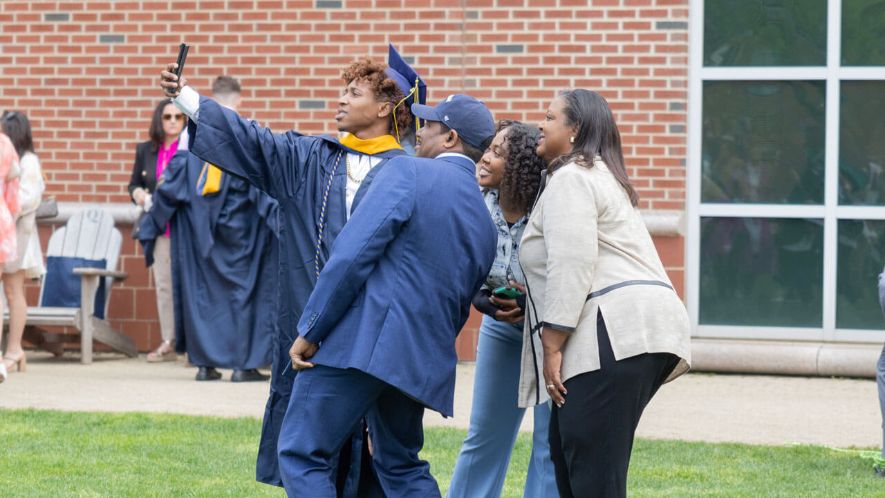 Family poses with graduate for a selfie