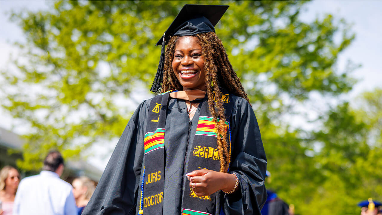 Business student smiling in her cap and gown