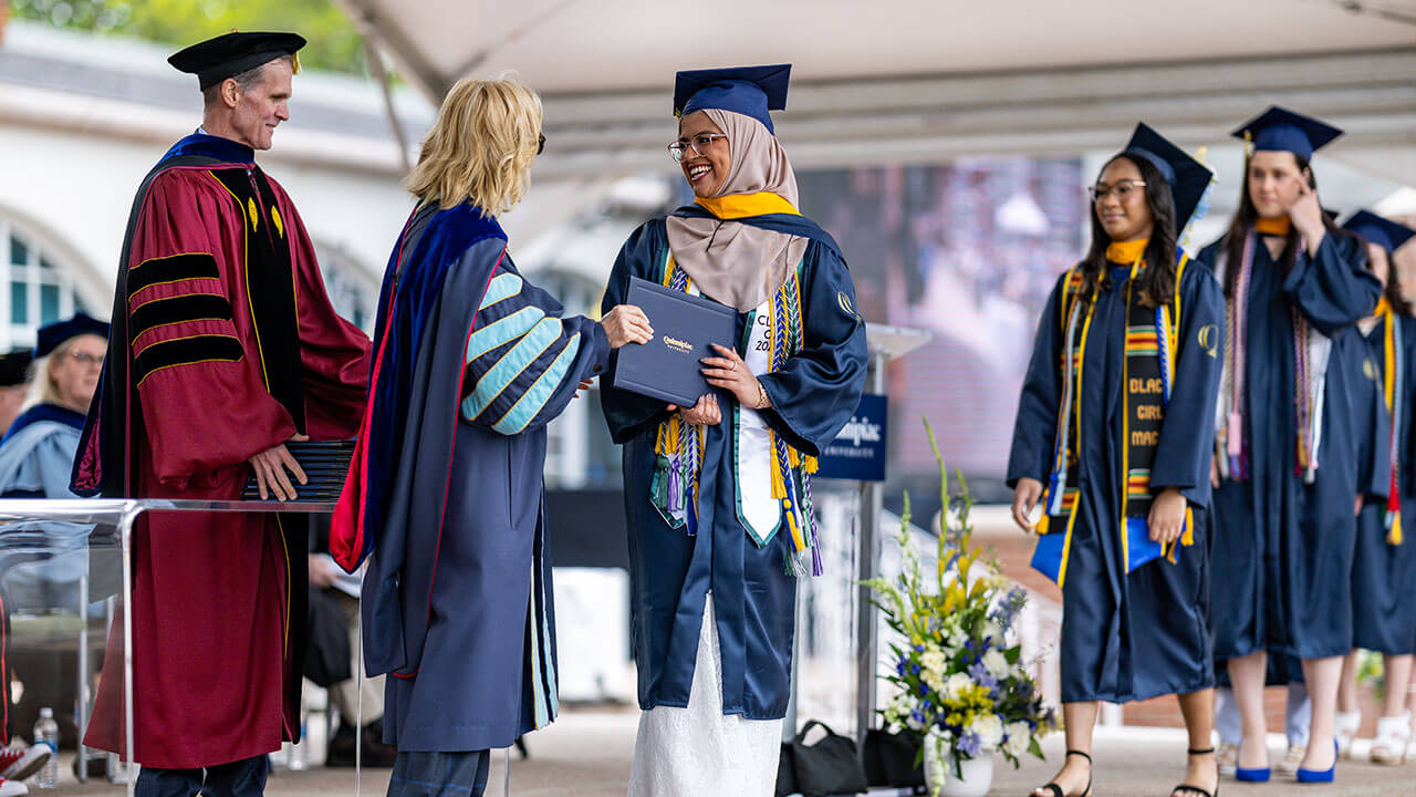 graduate smiles at Judy Olian