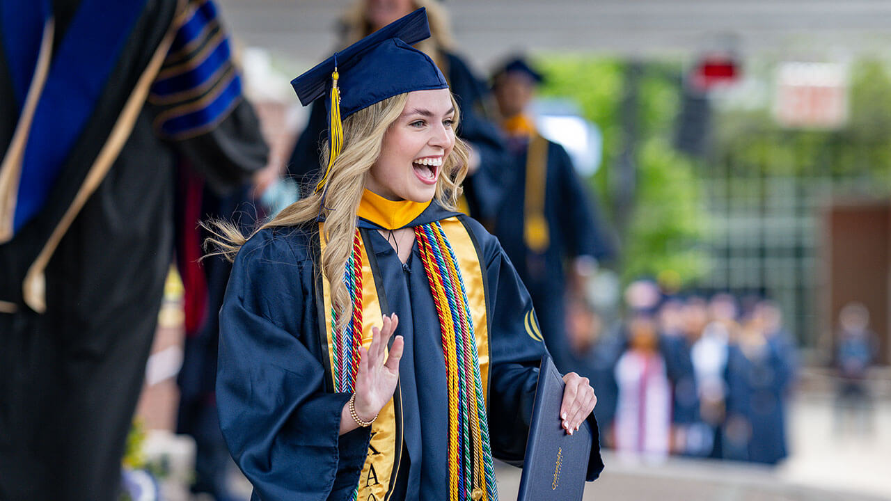 graduate waves from the stage