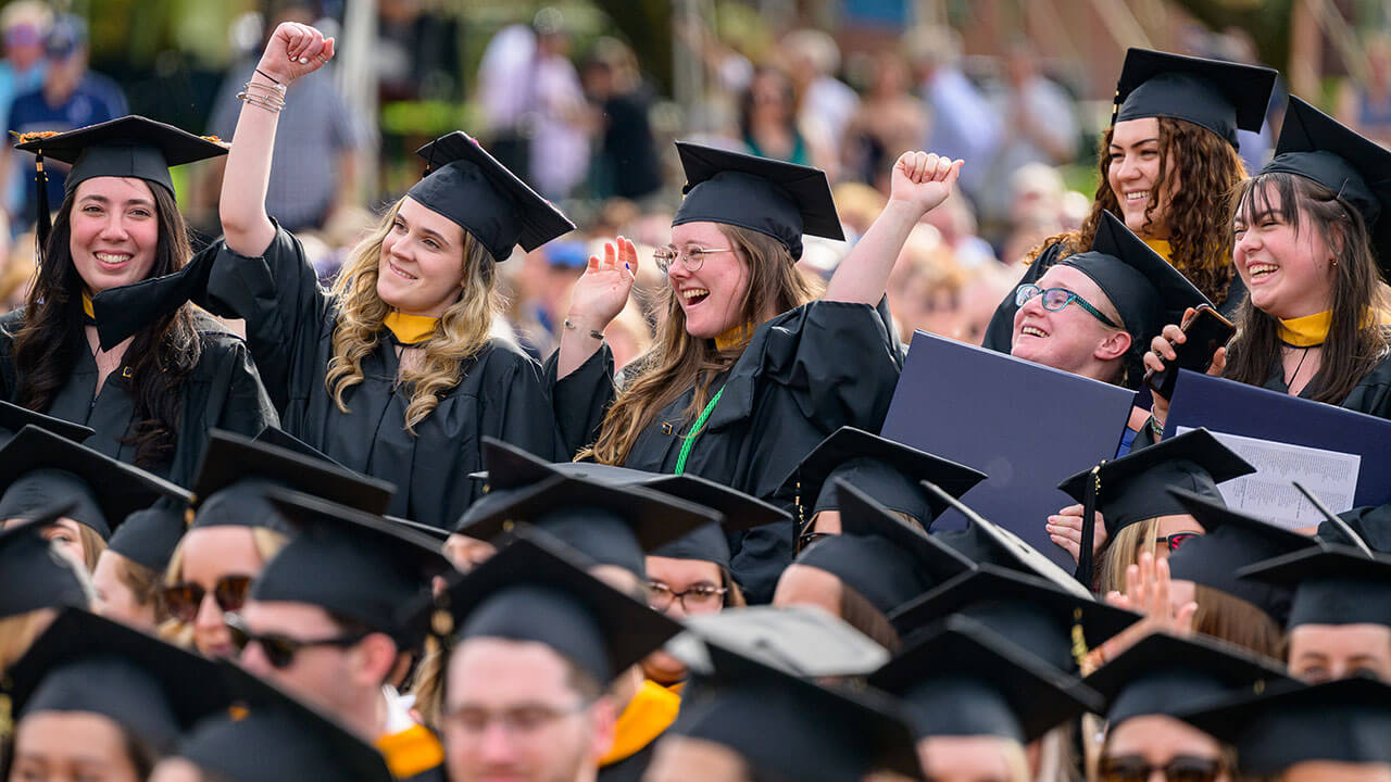 row of graduates cheer