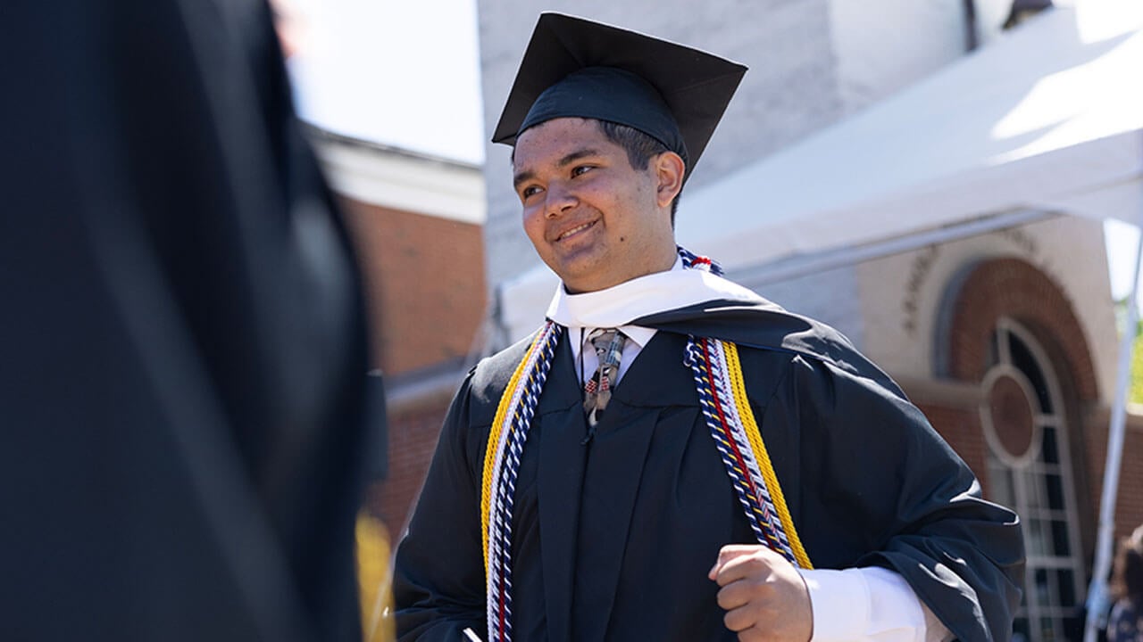 graduate smiles as he walks