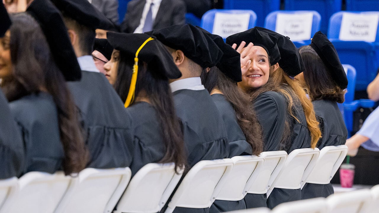 Med grad student waving up to the crowd