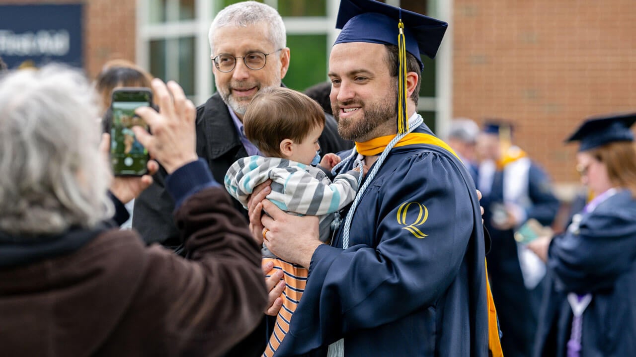 Quinnipiac graduate takes a photo with their family