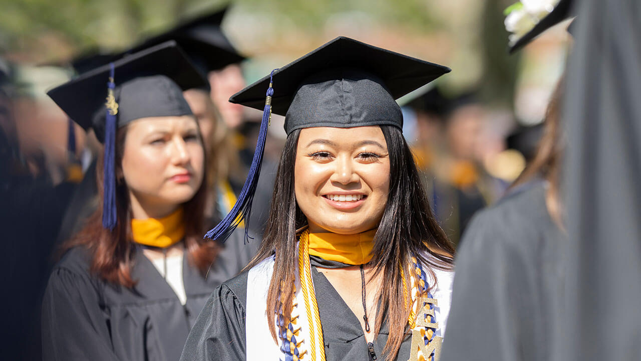 Student smiling in her cap and gown