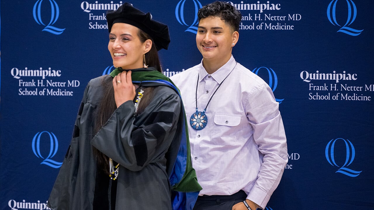 Graduate poses with family after getting their hood