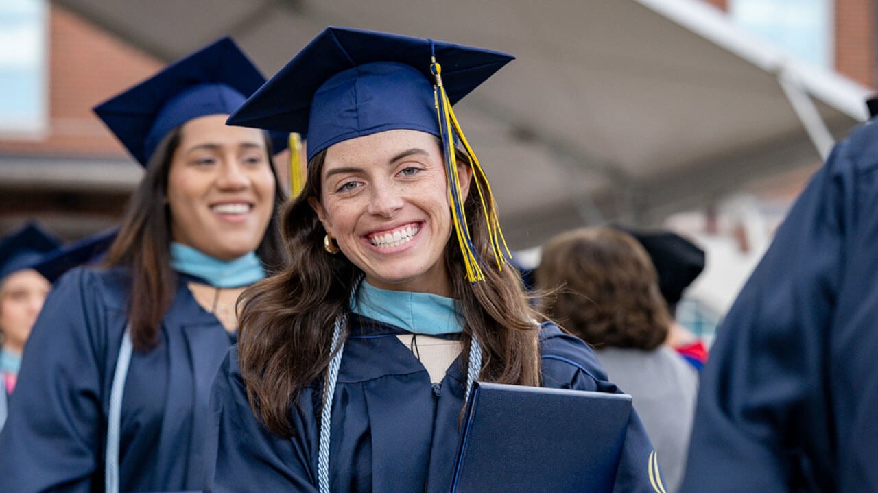 2024 graduate smiles brightly for a photo after being awarded with their diploma.