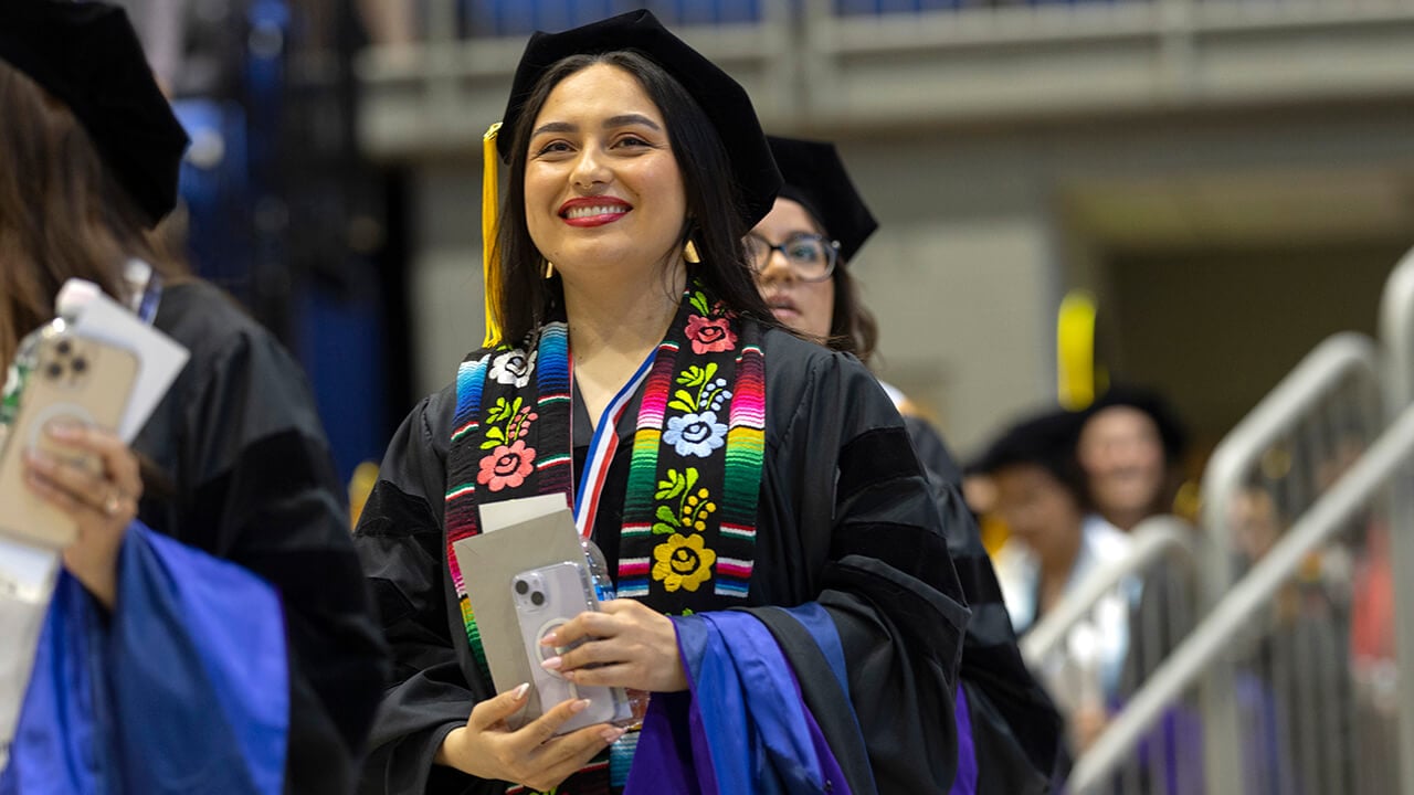 Graduate smiles during procession