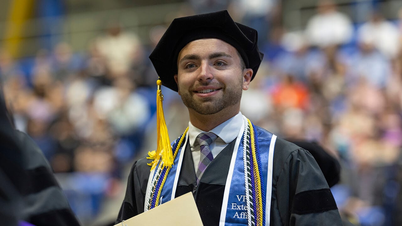 Graduate smiles at crowd