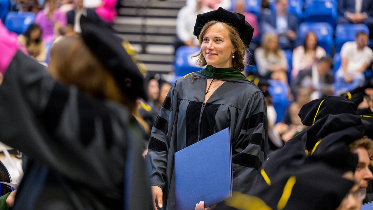 Graduate stands alone and smiles