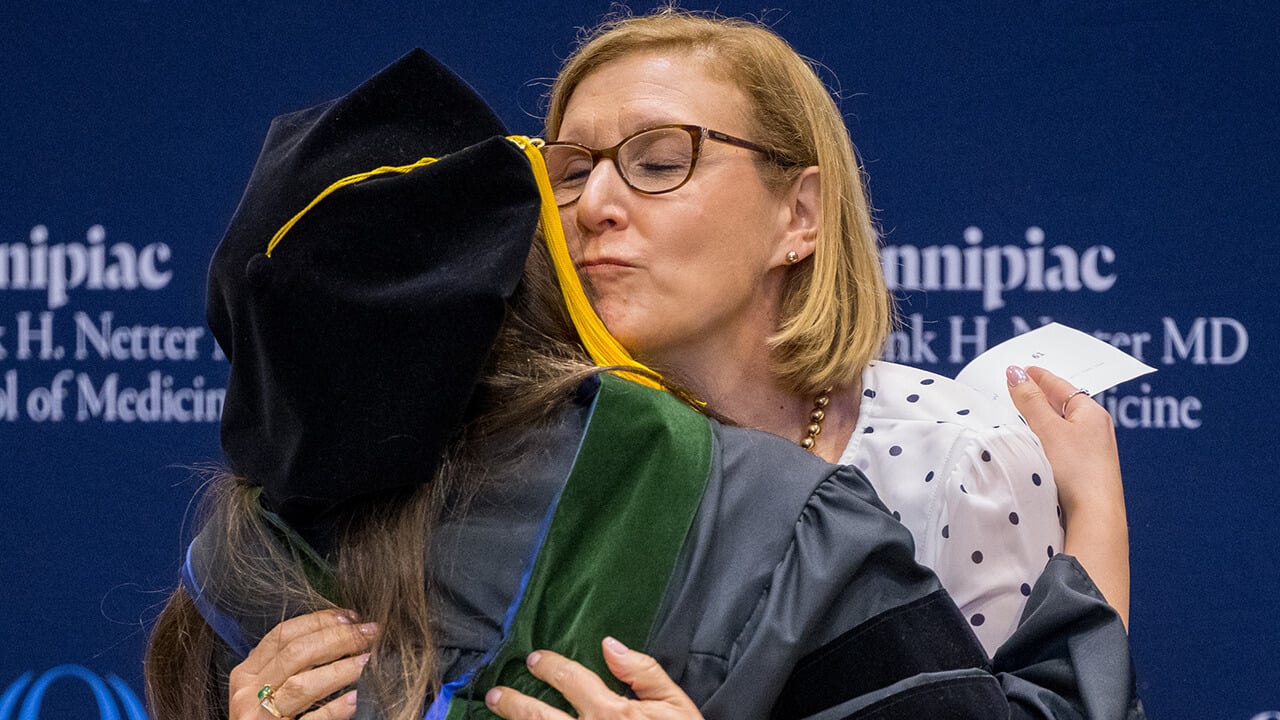 Graduate embraces family after receiving hood