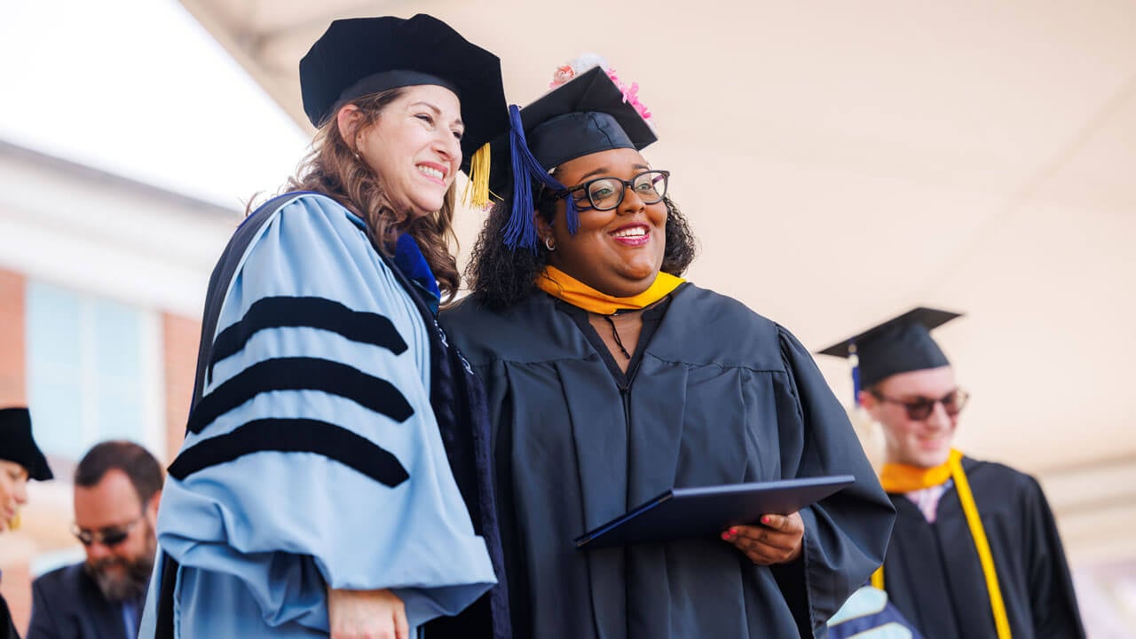 SOB Graduate poses with Dean Raider