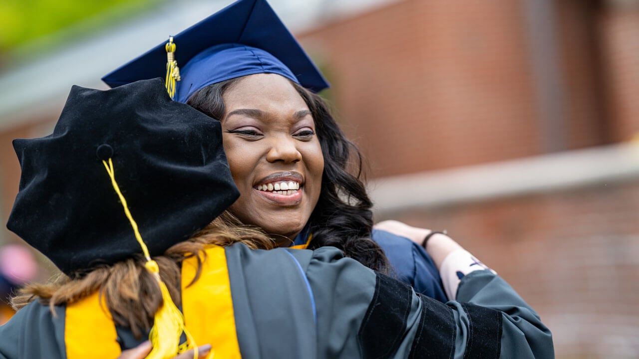 Graduate hugging their professor