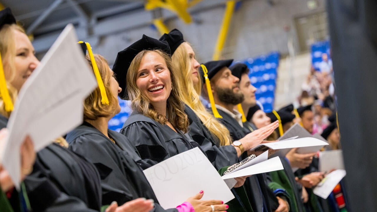 Graduates sitting and looking at each other with smiles