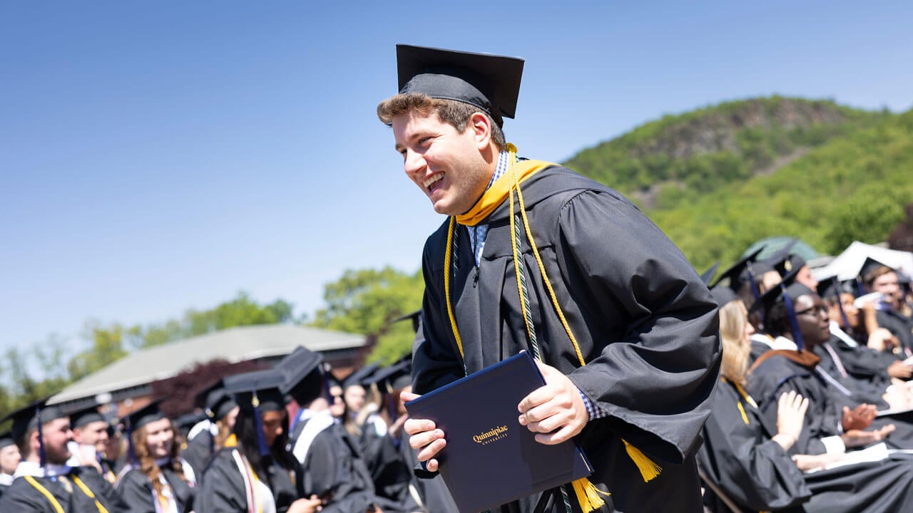 Graduate holds diploma excited and cheering