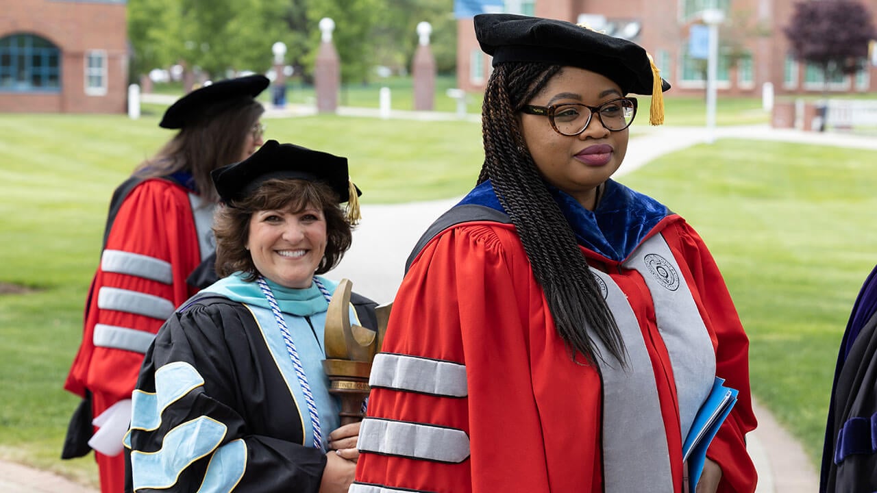 dean and faculty pose smiling with the honorary wooden mace