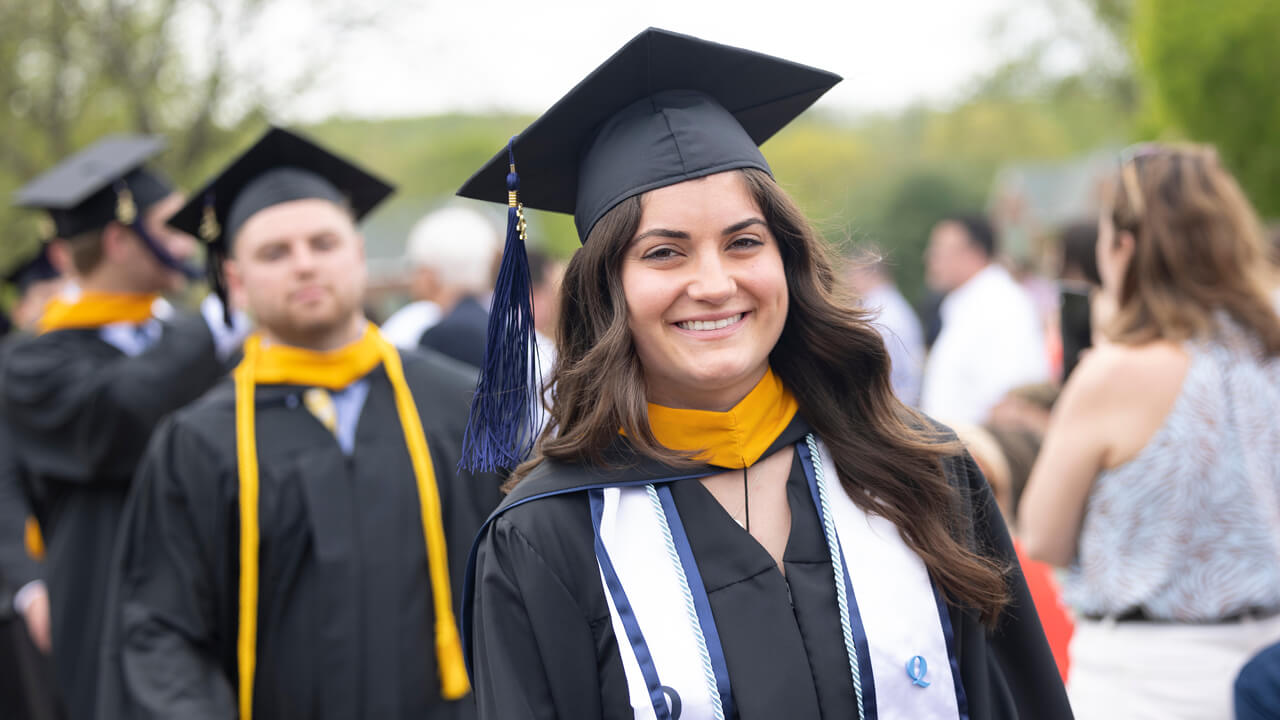 Graduate student smiles for a photo on the Quad