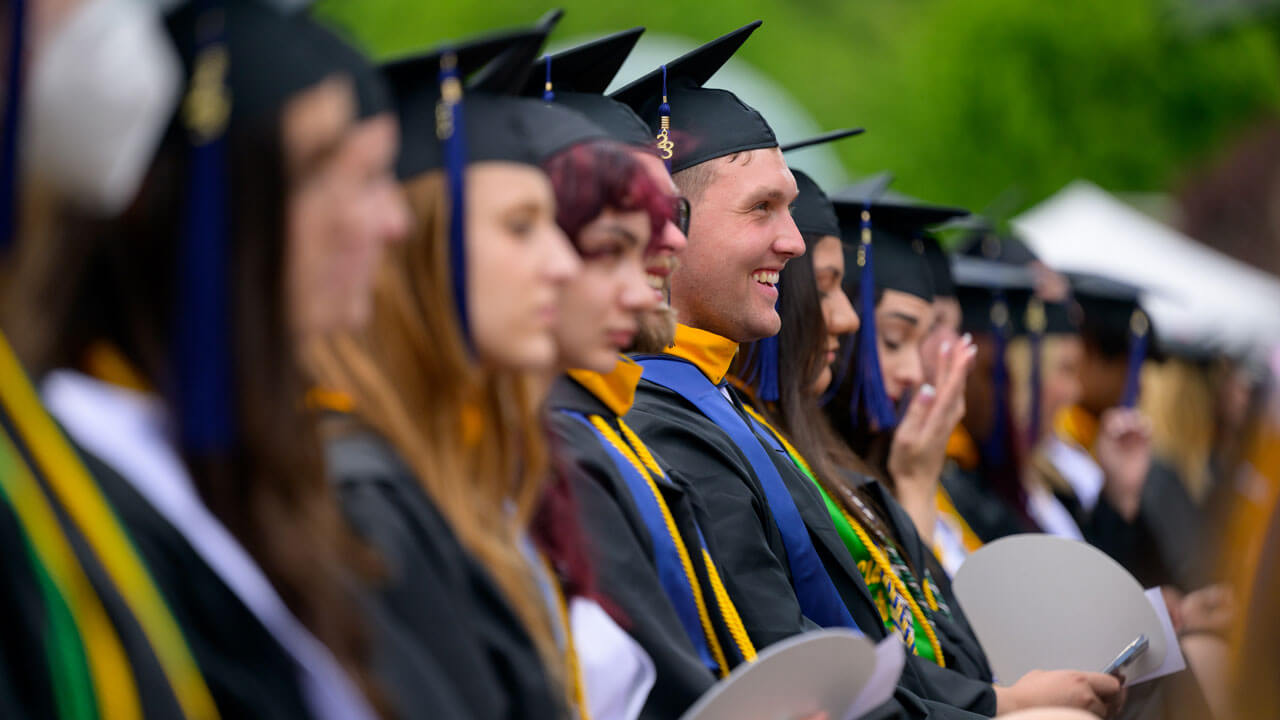 Graduates happily sitting and smiling all together