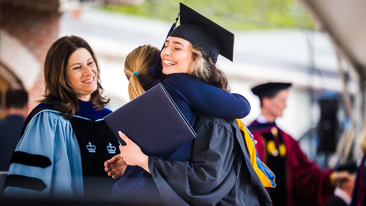 Graduate Madison Stout hugs her sister Charity Kuchyt on stage