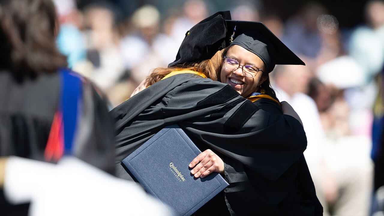 graduate tightly hugs professor