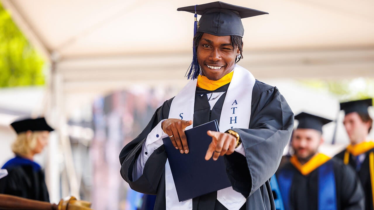 Graduate student look at the camera and smiles