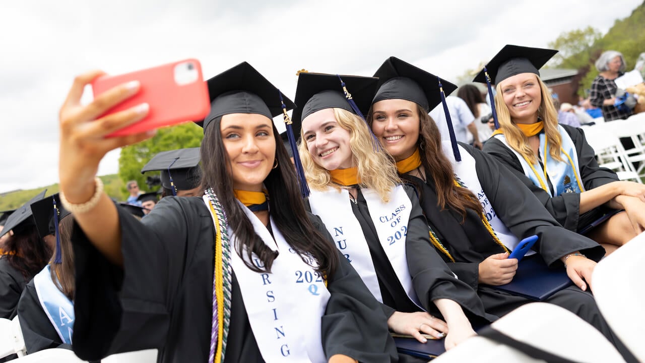 Graduates take a selfie during the ceremony