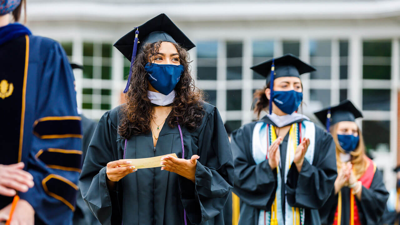 Graduate holding name card at commencement ceremony