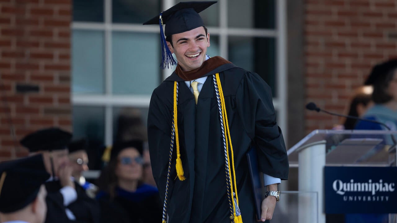 Graduate cheerfully smiles