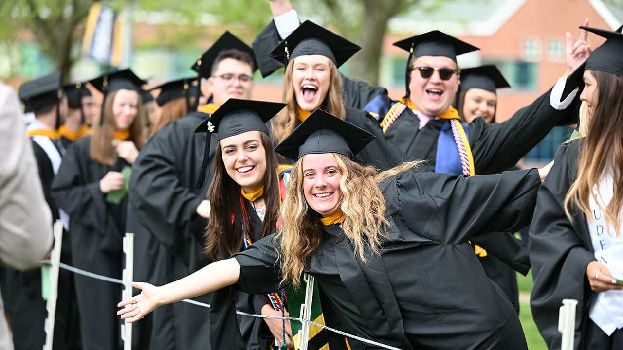 Graduates cheer as they walk into the Commencement ceremony on the quad