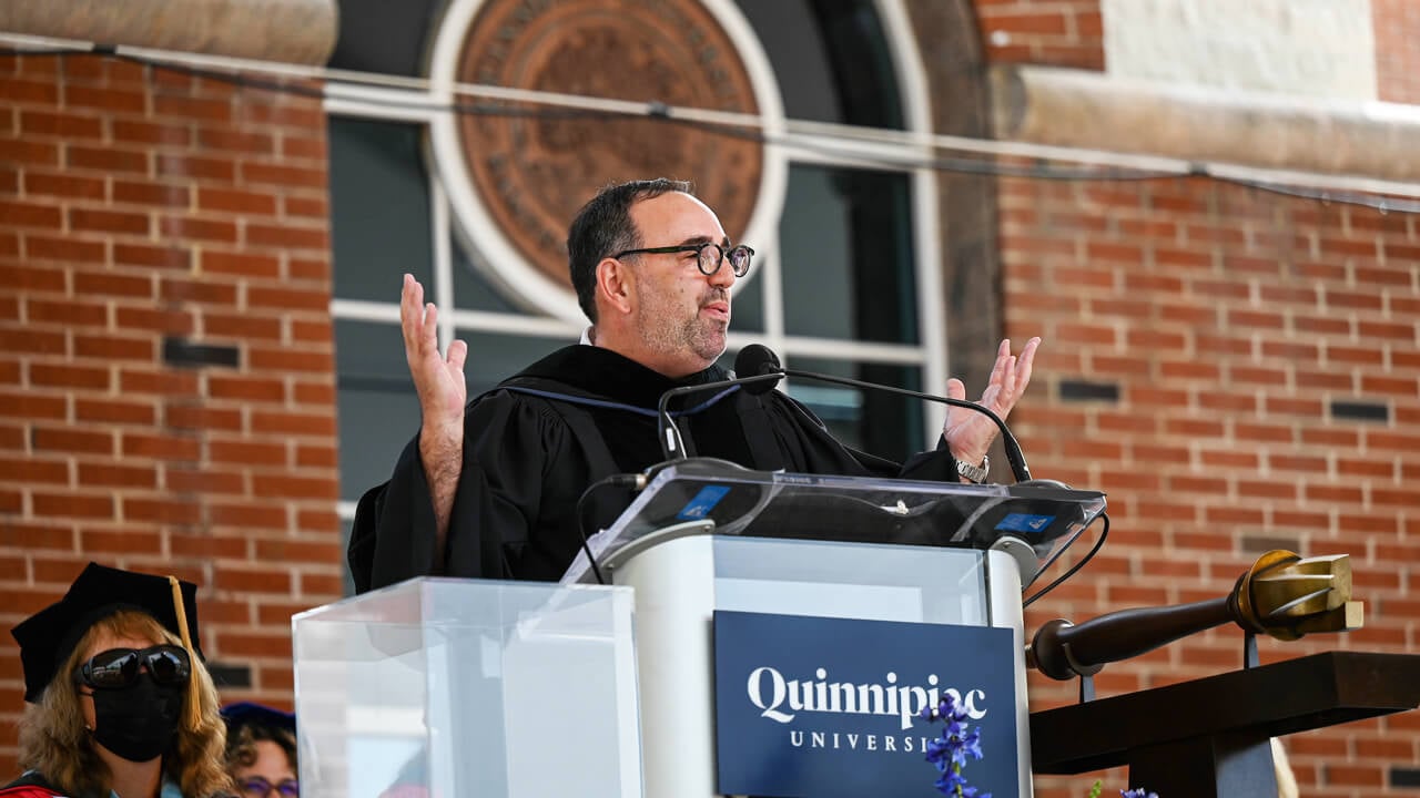 Jeffrey Flaks speaks to the crowd from a podium in front of the library