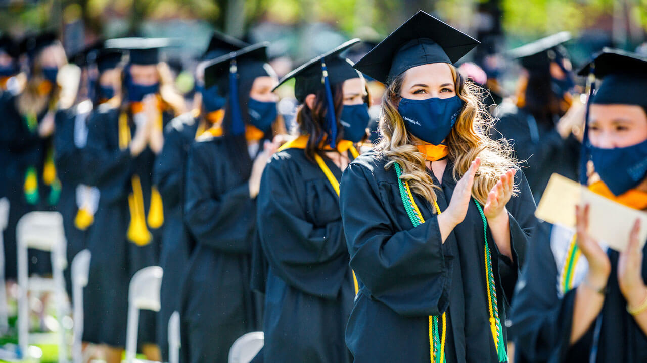 Graduates clapping during commencement ceremony