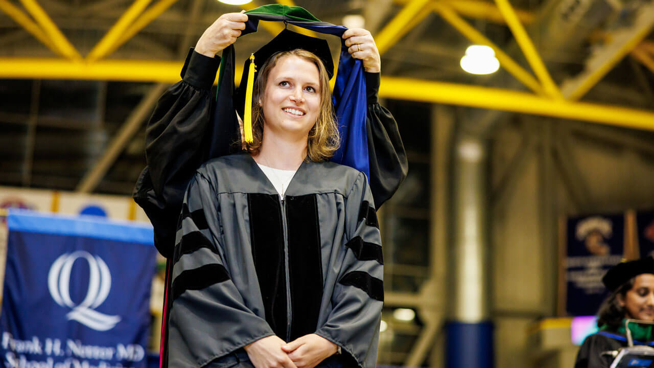 A hood being placed on a graduate student during commencement