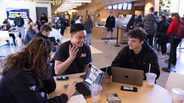 Students study and talk together at a table in the Recreation and Wellness Center which is buzzing with students