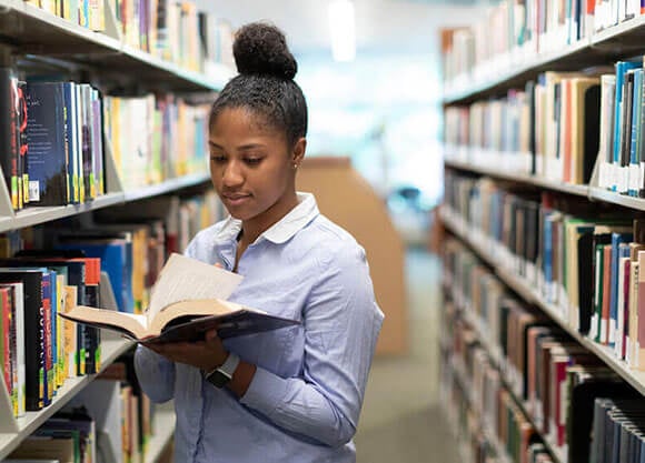 Student reads a book in the library