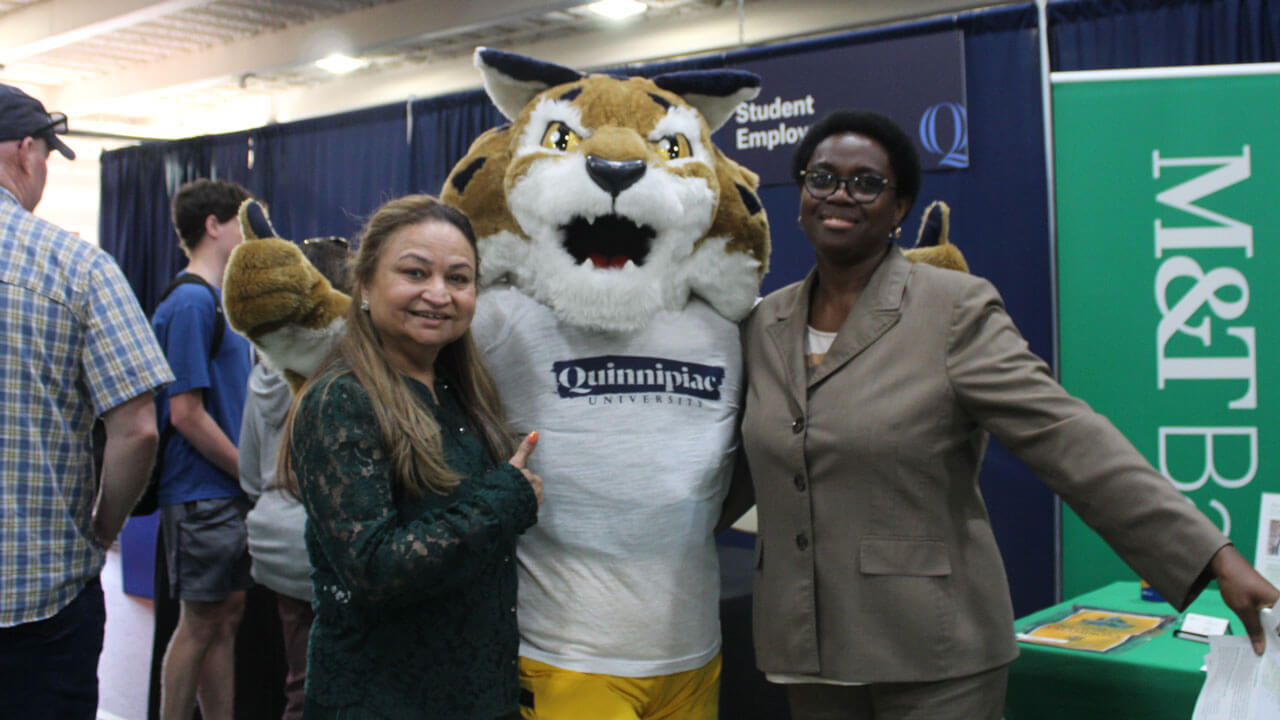 Boomer shows a thumbs up taking a photo with M&T Bank Arena representives