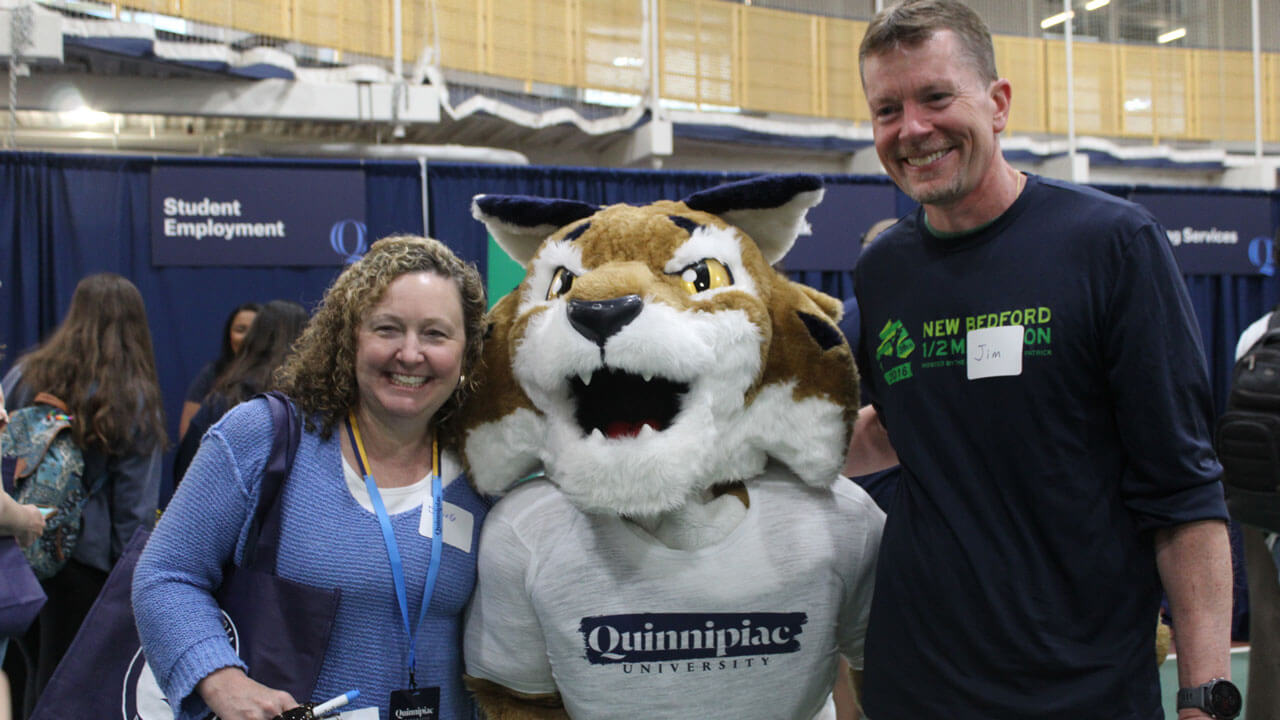 Orientation family happily smiling as they take a photo with Boomer