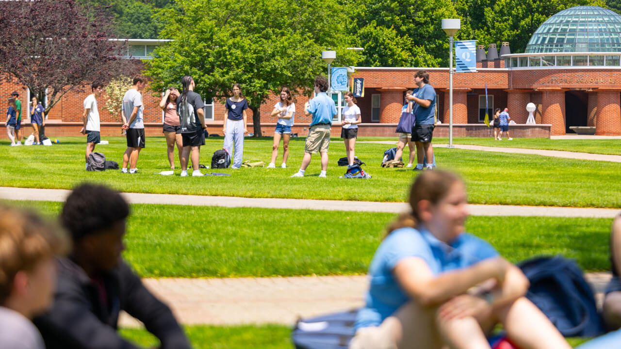 People sitting and standing on the Quad during Orientation