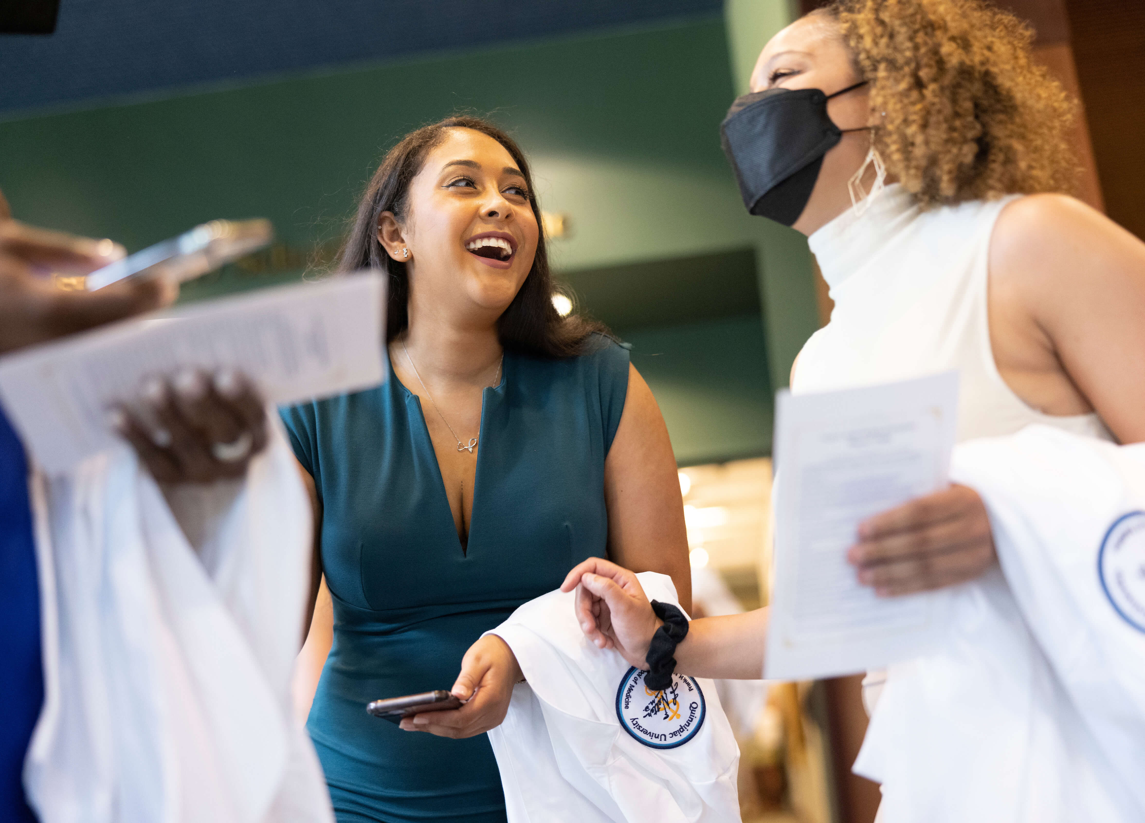 Two students laugh while at a recommitment to medicine ceremony recommitment to medicine ce