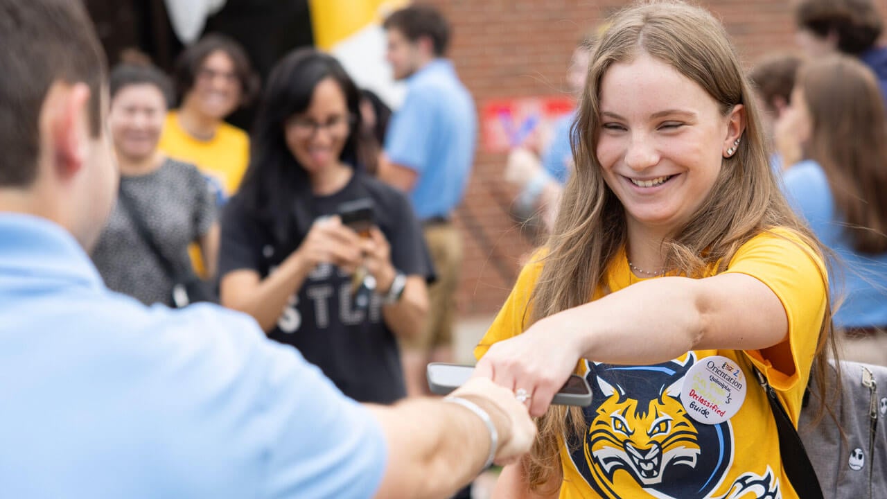 Quinnipiac incoming first-year fist bumps Orientation Leader