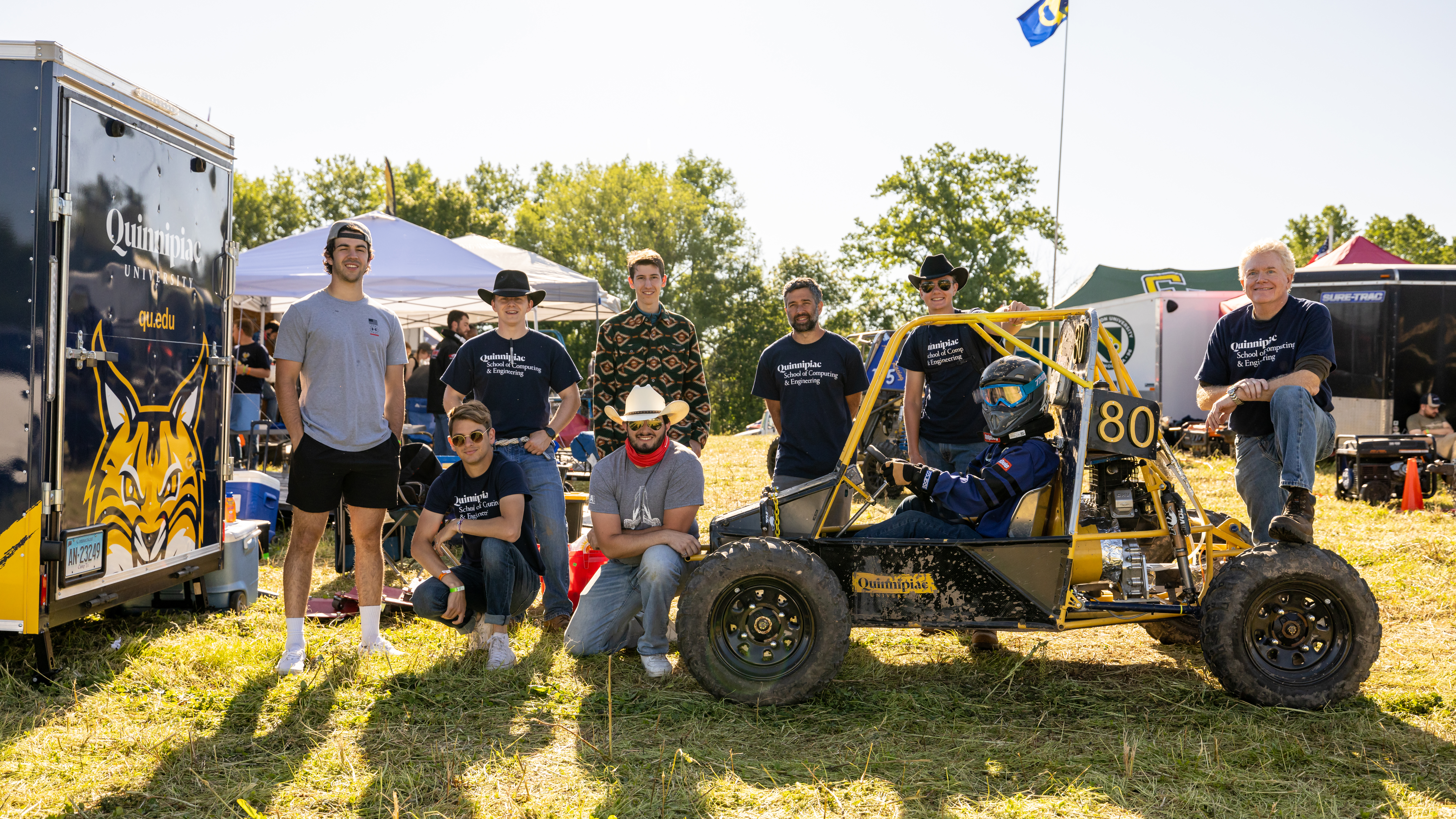 Students pose next to their vehicle