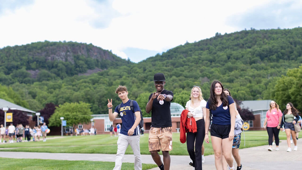 Men and women students walking across the quad with mountains in the background