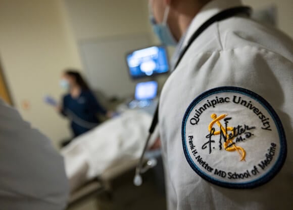 Quinnipiac School of Medicine badge on a medical student's sleeve.