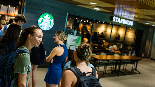 Students talk with each other in line at the Starbucks in the Quinnipiac student center