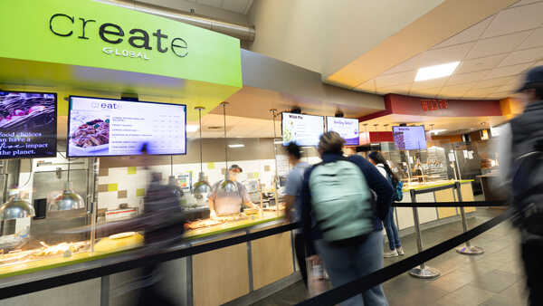 Students walk by the Create Global dining station in the Mount Carmel Campus cafe
